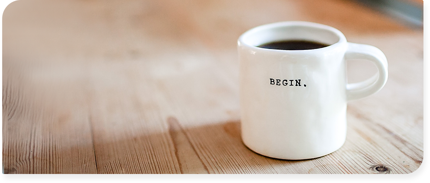 Tasse de café ou est écrit begin dessus, posée sur une table